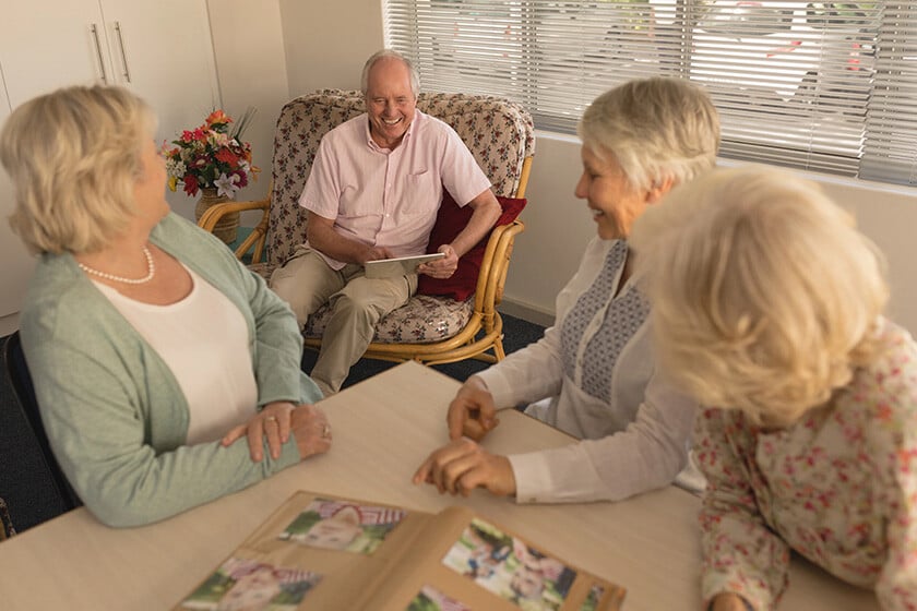 Front view of group of active senior people interacting with each other at nursing home