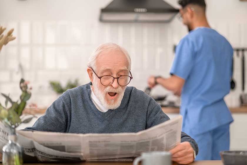 Male pensioner reading news before the morning meal